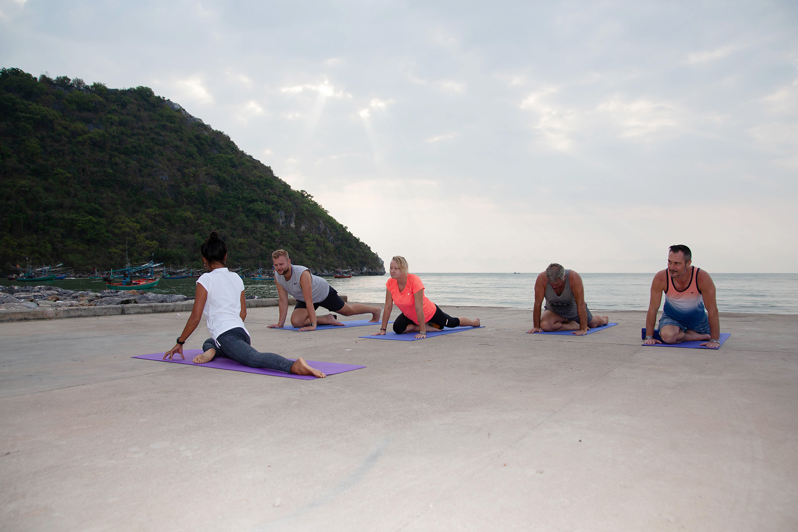 "Participants practicing therapeutic yoga at Tao Rehab Thailand in a serene outdoor setting."